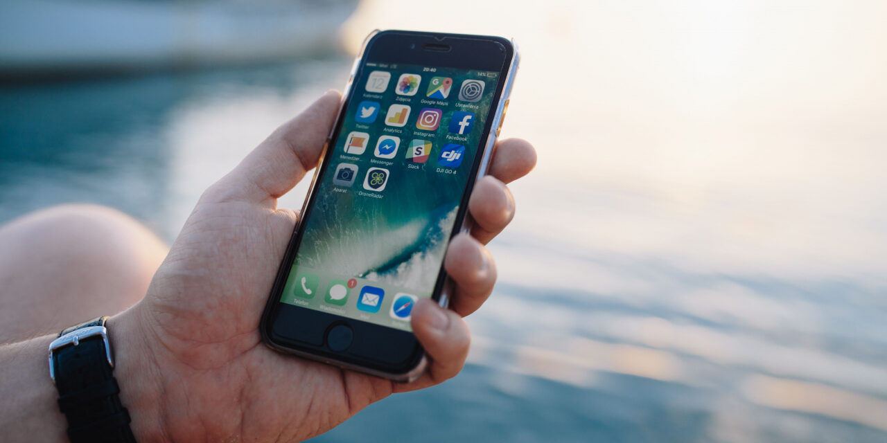 kaboompics_Mobile phone in man’s hands near the sea (1)